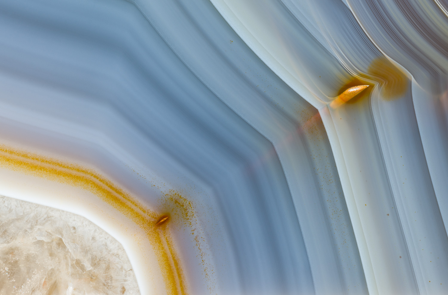 Macro photograph showing characteristic banding, along with a couple of inclusions, in a Brazilian agate. Image #3937