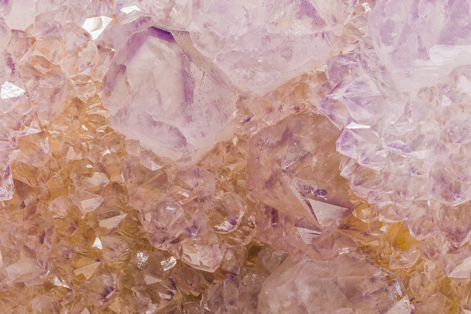 Macrophotograph of a small portion of a Cactus quartz (a.k.a. Spirit quartz) crystal cluster with purple amethyst.  The orange...